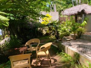 a garden with chairs and a table and a fence at Eagle Point Riverside Stay in Weligama