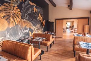 a restaurant with tables and chairs and a mural at Golf Resort de Digne-les-Bains by Adonis in Digne-les-Bains
