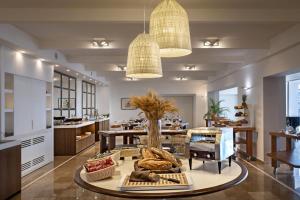 a large kitchen with a table and a dining room at El Faro Hotel & Spa in Porto Conte