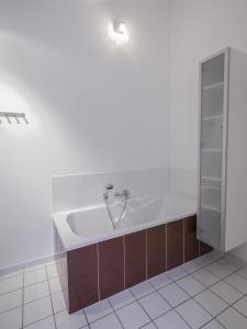 a bath tub in a bathroom with a tile floor at La Moutière in Colonzelle +34 photos