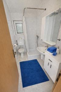 a bathroom with a toilet sink and a blue rug at Perla Mare in Sumartin +44 photos