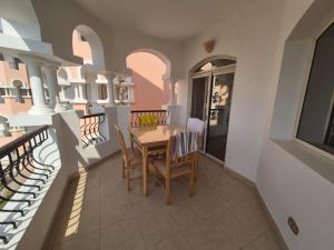 a dining room with a table and chairs on a balcony at K31 Peaceful 2 Bedrooms Nile Resort Flat in Luxor in Luxor