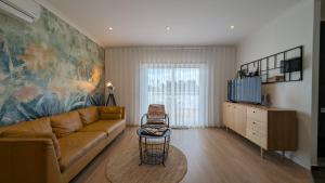 a living room with a couch and a tv at Pine Tree Seaside Apartments 500m to Beach in Albufeira