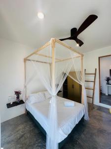 a bedroom with a bed with a ceiling fan at Private Beach House in AguaBlanca Peaceful Getaway in Playa Agua Blanca +20 photos