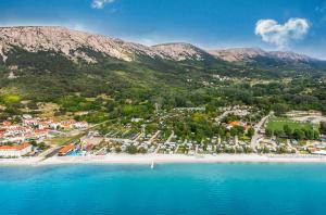 an aerial view of a beach with mountains in the background at Camping Baska in Krk