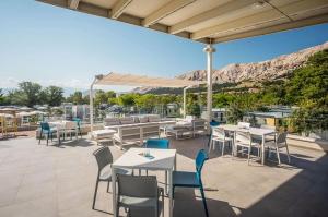 a patio with tables and chairs and a view at Camping Baska in Krk