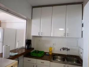 a kitchen with white cabinets and a sink at Apartamento con vistas al mar! Comaruga in La Playa +35 photos