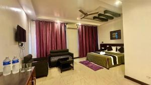 a hotel room with a bed and a couch at Hotel Black and White International in Bhairāhawā
