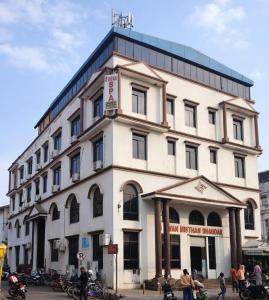 a large white building with people standing in front of it at Hotel Black and White International in Bhairāhawā