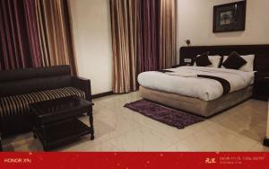 a bedroom with a bed and a chair and a couch at Hotel Black and White International in Bhairāhawā