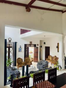 a living room with couches and a table and chairs at Akshi Hostel in Kandy