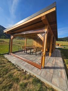 a wooden pavilion with a picnic table in a field at Chalet pod Skalou in Liptovská Anna