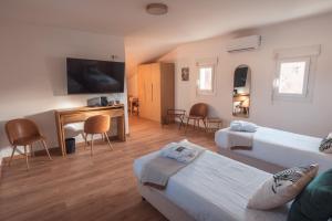 a hotel room with two beds and a desk at Golf Resort de Digne-les-Bains by Adonis in Digne-les-Bains