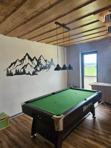 a pool table in a room with a mural of mountains at Chalet pod Skalou in Liptovská Anna