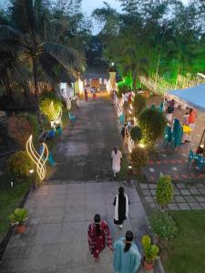 a group of people walking down a street with lights at Manor Backwater Resort in Kumarakom +62 photos