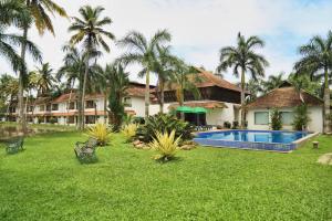 a resort yard with a swimming pool and palm trees at Manor Backwater Resort in Kumarakom