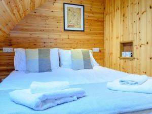 a bed in a wooden room with towels on it at 2 Bed in Rhayader oc-90274 in Saint Harmon