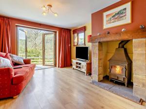 a living room with a fireplace and a red couch at 4 Bed in Llanidloes oc-95968 in Van