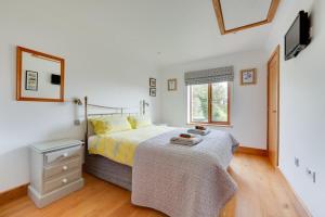 a bedroom with a bed and a dresser and a window at 3 Bed in Walberswick oc-htroy2 in Walberswick