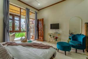 a bedroom with a bed and a chair and a television at The Premium Hood Bir Billing in Bīr