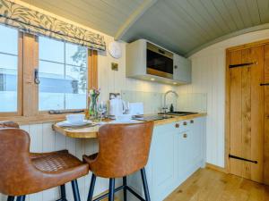 a kitchen with a counter and two bar stools at 1 Bed in Rhayader oc-90284 in Saint Harmon