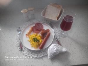 a plate of breakfast food with sausage eggs and bacon at De Rams boutique guest house in Witnek +9 photos