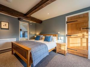 a bedroom with a large bed with blue pillows at 4 Bed in Denbigh oc-62947 in Llannefydd
