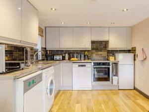 a large kitchen with white appliances and wooden floors at 2 Bed in Brecon oc-bn100 in Cray +26 photos