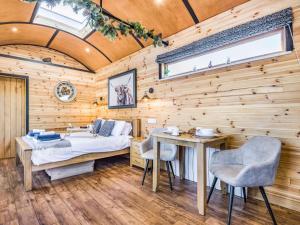 a bedroom with a bed and a table and chairs at 1 Bed in Rhayader oc-90285 in Saint Harmon