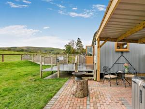 a patio with a table and a bird feeder next to a house at 1 Bed in Rhayader oc-90285 in Saint Harmon