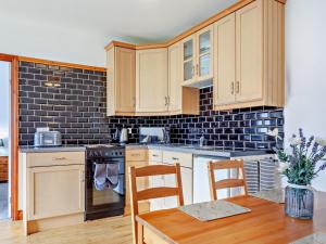 a kitchen with wooden cabinets and a table and chairs at 2 Bed in Bristol oc-37147 in Chew Magna +14 photos