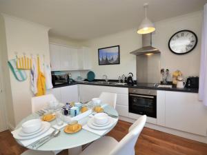 a kitchen with a table and chairs and a clock at 2 Bed in Minehead oc-75338 in Minehead