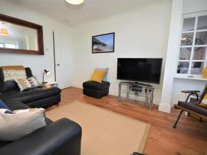 a living room with a couch and a flat screen tv at 2 Bed in Minehead oc-75338 in Minehead