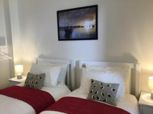 a bedroom with two beds and a picture on the wall at 2 Bed in Minehead oc-75338 in Minehead