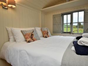 a bedroom with a large white bed with two tigers pillows at 1 Bed in Rhayader oc-90277 in Saint Harmon