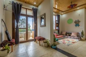 a living room with a couch and a table at The Premium Hood Bir Billing in Bīr