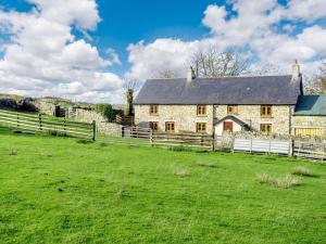an old stone house with a fence in a field at 4 Bed in Abergavenny oc-88014 in Llanover