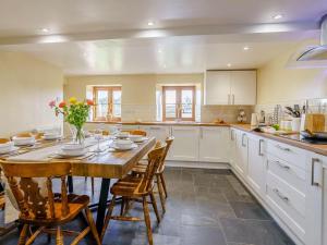 a kitchen with a large wooden table and chairs at 4 Bed in Abergavenny oc-88014 in Llanover