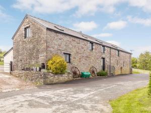 an old brick building with two wagonwheels in front of it at 2 Bed in Brecon oc-bn310 in Cray
