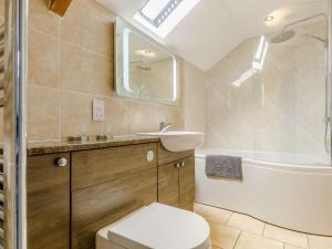 a bathroom with a toilet and a sink and a tub at 2 Bed in Brecon oc-bn310 in Cray