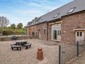a brick building with a table and benches in front of it at 3 Bed in Crickhowell oc-bn124 in Tretower