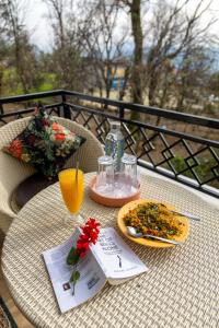 a table with a plate of food and a drink at The Premium Hood Bir Billing in Bīr