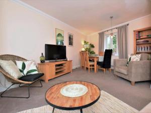 a living room with a television and a table at 3 Bed in Bampton oc-77931 in Bampton
