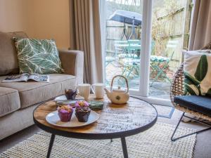 a living room with a coffee table with cupcakes on it at 3 Bed in Bampton oc-77931 in Bampton