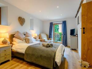 a bedroom with a large bed and a chair at 3 Bed in Brecon oc-88249 in Brecon