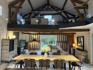 a dining room with a wooden table and chairs at Le Jardin d'Elusa in Eauze