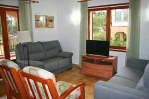 a living room with a couch and a tv at Isern Dalt 3H in Pals
