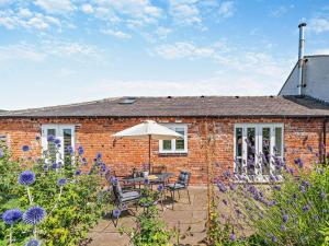 a brick house with a table and chairs and an umbrella at 1 Bed in Derby oc-76518 in Tutbury