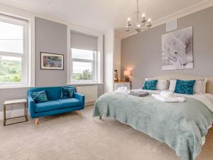 a bedroom with a bed and a blue chair at 4 Bed in Matlock oc-88011 in Matlock