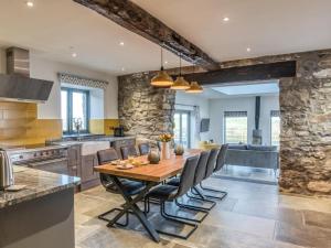 a large kitchen with a wooden table and chairs at 4 Bed in Denbigh oc-76475 in Llannefydd